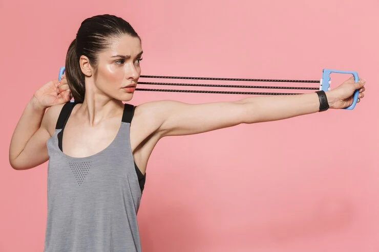 a amizing girl wearing t shirt doing shoulder exercise with resistance band 